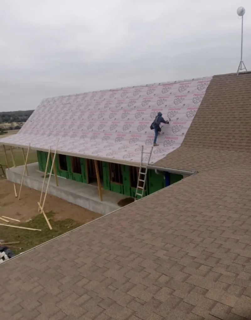 Worker preparing underlayment for a metal roof installation in Siesta Key